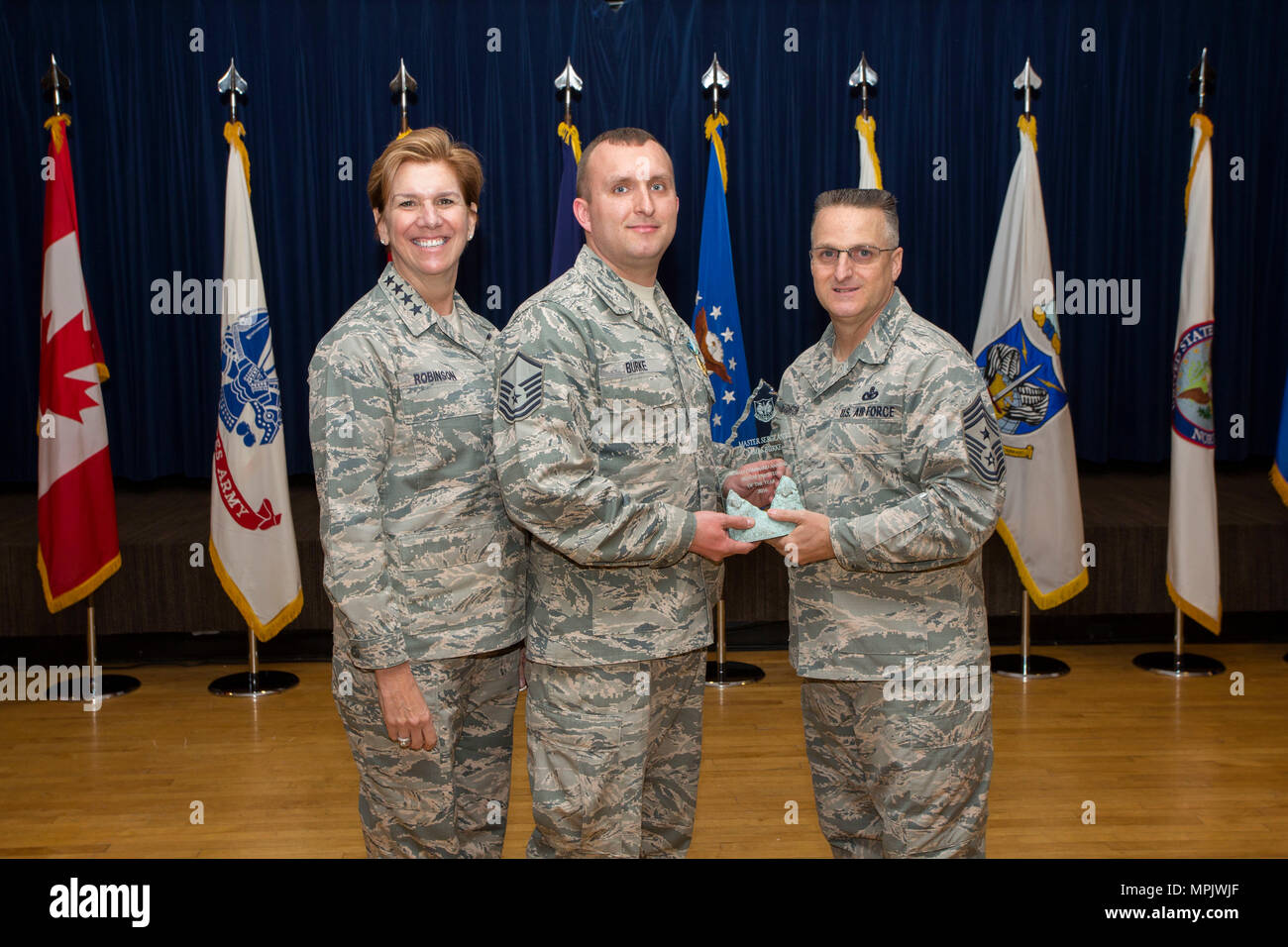 NORAD ( North American Aerosapce Defense Command) Commander Lori Robinson and Chief Master Sgt. Harold Hutchinson, right, NORAD's Senior Enlisted Leader present the NORAD Senior Noncomisioned Officer of the Year award to Master Sgt James Burke, a member of the 224th Air Defense Group of the New York Air National Guard, on March 14, 2017 during a ceremony at NORAD headquarters on Colorado Springs, CO. The 224th Air Defense Group is manned by New York Air National Guard Airmen and is a component of the Easter Air Defense Sector which coordinates air defense for the United States east of the Miss Stock Photo