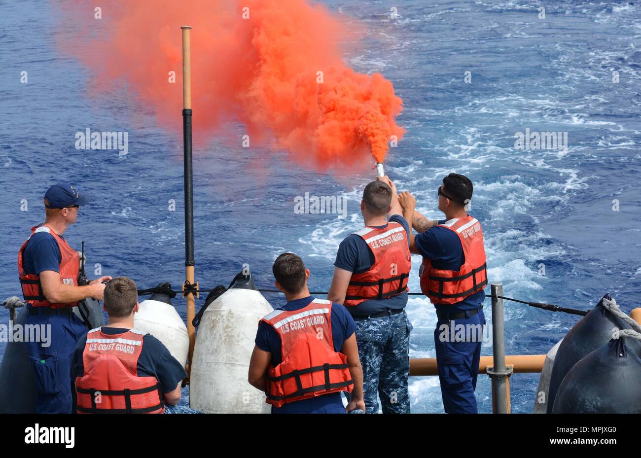 A Coast Guard crewmember provides pyrotechnic training to a U.S. Naval Sea Cadet Corps cadet aboard the Coast Guard Cutter Galveston Island (WPB 1349) off Honolulu, March 11, 2017. The USNSCC is a Navy-based organization, which serves to teach teens about sea-going military services, U.S. naval operations and training, community service, discipline and teamwork. (U.S. Coast Guard photo by Petty Officer 1st Class Joe Jorgenson/Released) Stock Photo