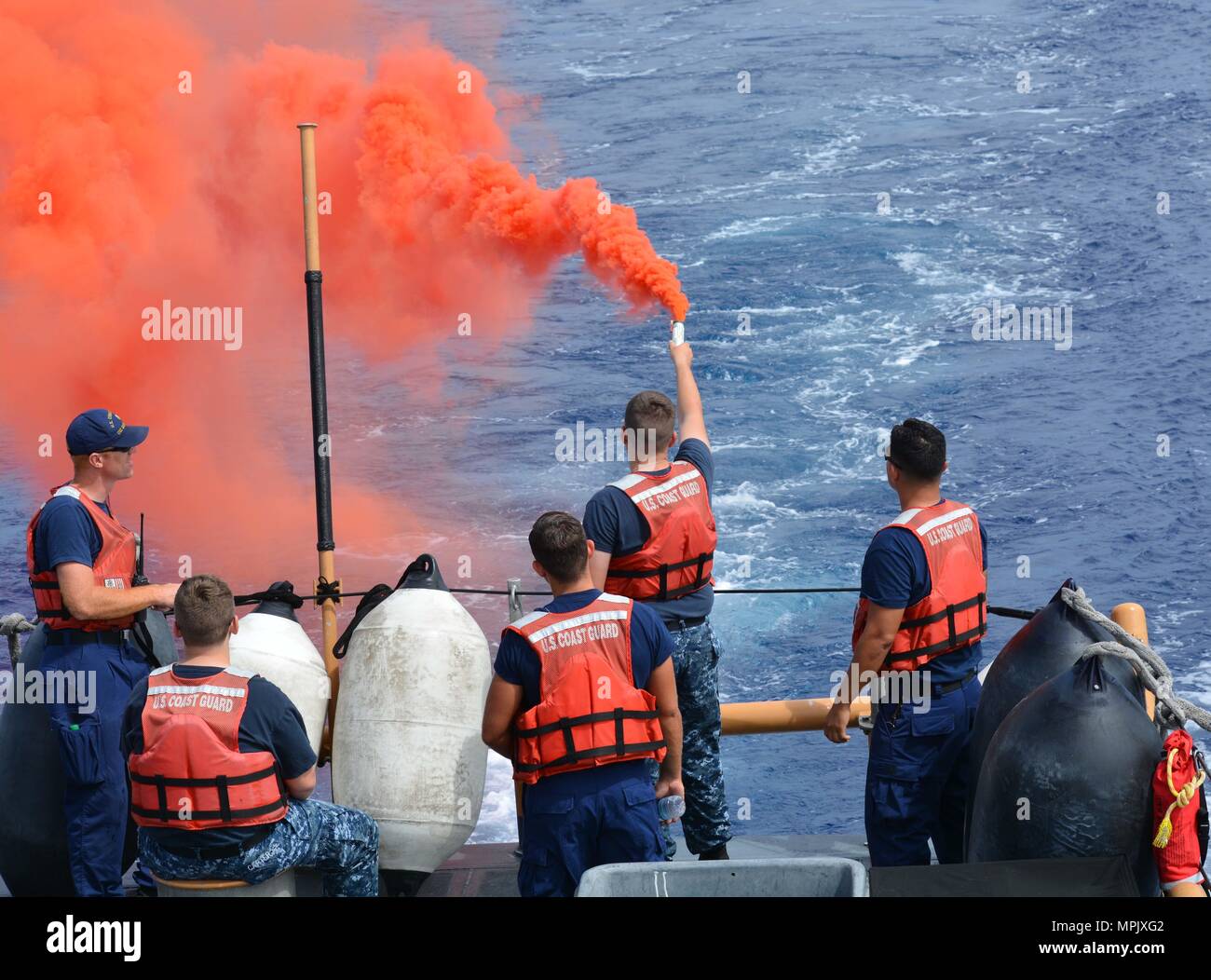 A Coast Guard crewmember provides pyrotechnic training to a U.S. Naval Sea Cadet Corps cadet aboard the Coast Guard Cutter Galveston Island (WPB 1349) off Honolulu, March 11, 2017. The USNSCC is a Navy-based organization, which serves to teach teens about sea-going military services, U.S. naval operations and training, community service, discipline and teamwork. (U.S. Coast Guard photo by Petty Officer 1st Class Joe Jorgenson/Released) Stock Photo