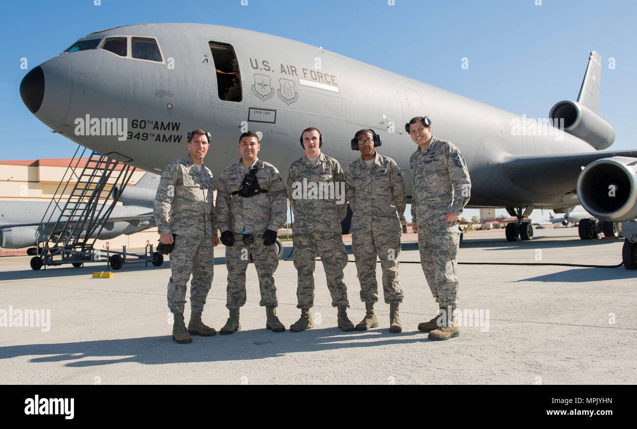 (Left to right), U.S. Air Force Col. John Klein, 60 Air Mobility Wing commander, and Chief Master Sgt Steven Nichols , 60 AMW command chief, Senior Airman Allen Gutierrez, Airman 1st Class Mark Burdick and A1C Caroline Wright teamed up  to conduct ramp operations service at Travis Air Force Base, Calif., Mar. 17, 2017 as part of the Works with Airmen Program. Burdick walked Klein through the process of transferring palletized cargo from a 60k Tunner loader onto a KC-10 Extender Aircraft . The Works with Airmen program is designed to allow wing leadership the opportunity to shadow junior enlist Stock Photo