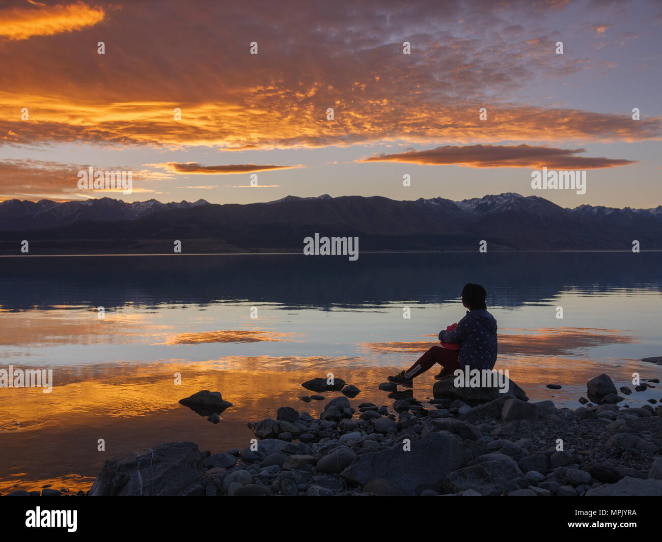 dreamer, silhouette of woman sitting on the lake wooden pier at sunset, human strength, psychology concept Stock Photo