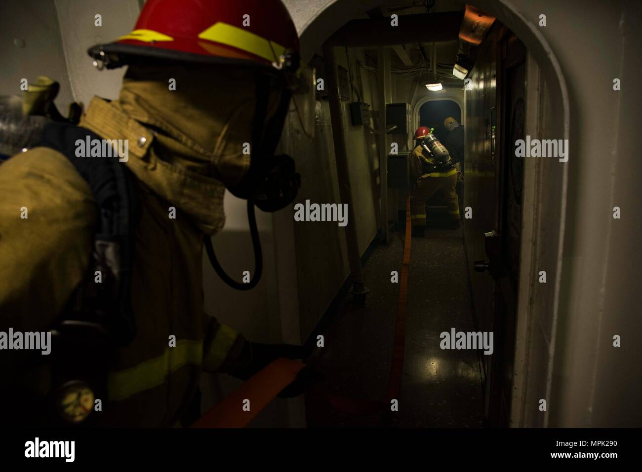 170208-N-KJ380-072    ATLANTIC OCEAN (Feb. 8, 2017) Mass Communication Specialist 3rd Class Robert Baldock, left, enters a space with the hose team in a passageway aboard the aircraft carrier USS Dwight D. Eisenhower (CVN 69) (Ike) during a general quarters drill. Ike is currently conducting aircraft carrier qualifications during the sustainment phase of the Optimized Fleet Response Plan (OFRP). (U.S. Navy photo by Mass Communication Specialist Seaman Neo Greene III) Stock Photo