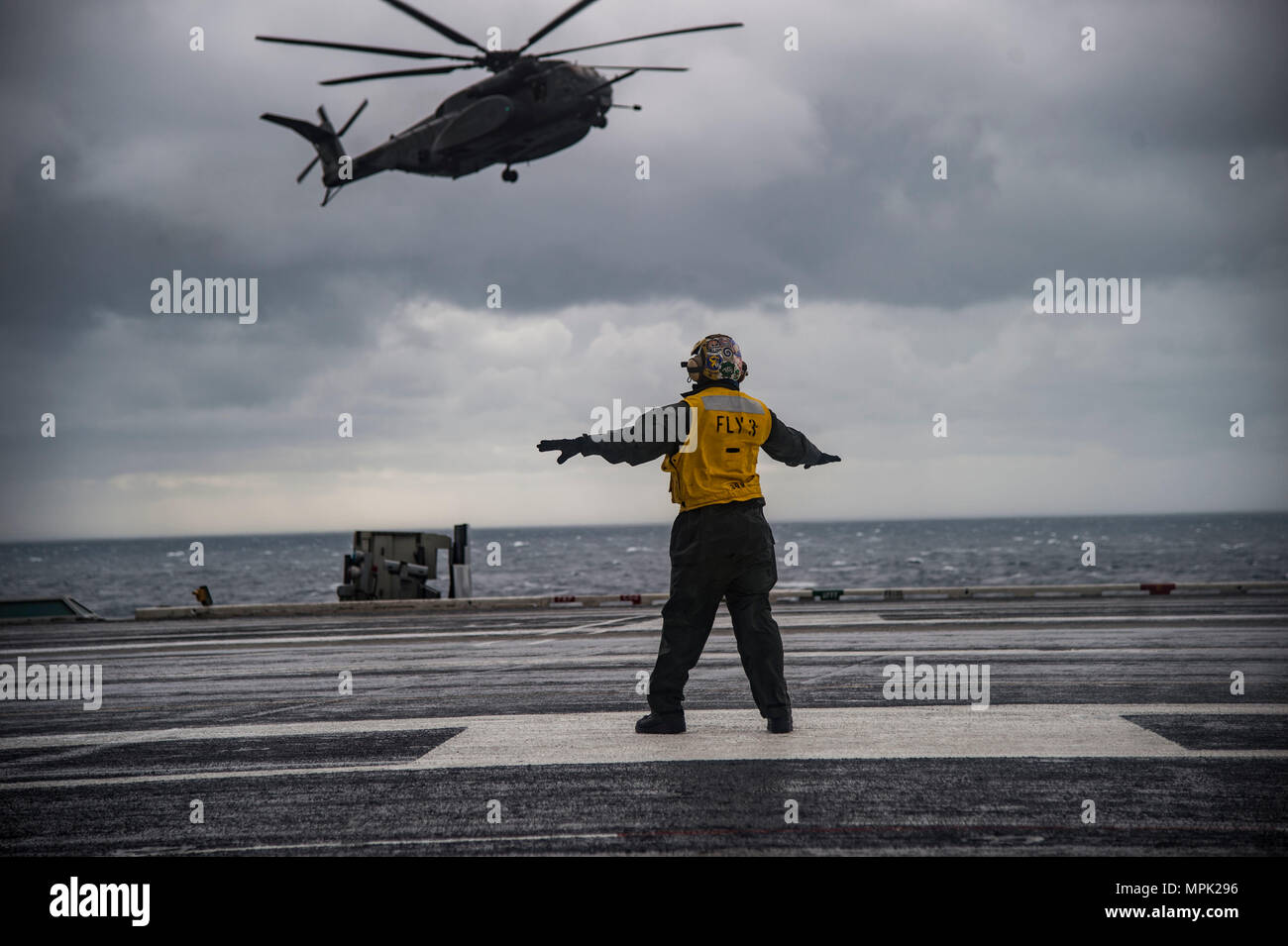 170208-N-OS569-042    ATLANTIC OCEAN (Feb. 8, 2017) Aviation Boatswain’s Mate 3rd Class (Handling) Joshua Broadbent directs an MH-53 Sea Dragon helicopter assigned to the Blackhawks of Helicopter Mine Countermeasures Squadron (HM) 15 onto the flight deck of the aircraft carrier USS Dwight D. Eisenhower (CVN 69) (Ike). Ike is currently conducting aircraft carrier qualifications during the sustainment phase of the Optimized Fleet Response Plan (OFRP). (U.S. Navy photo by Mass Communication Specialist Seaman Zach Sleeper) Stock Photo