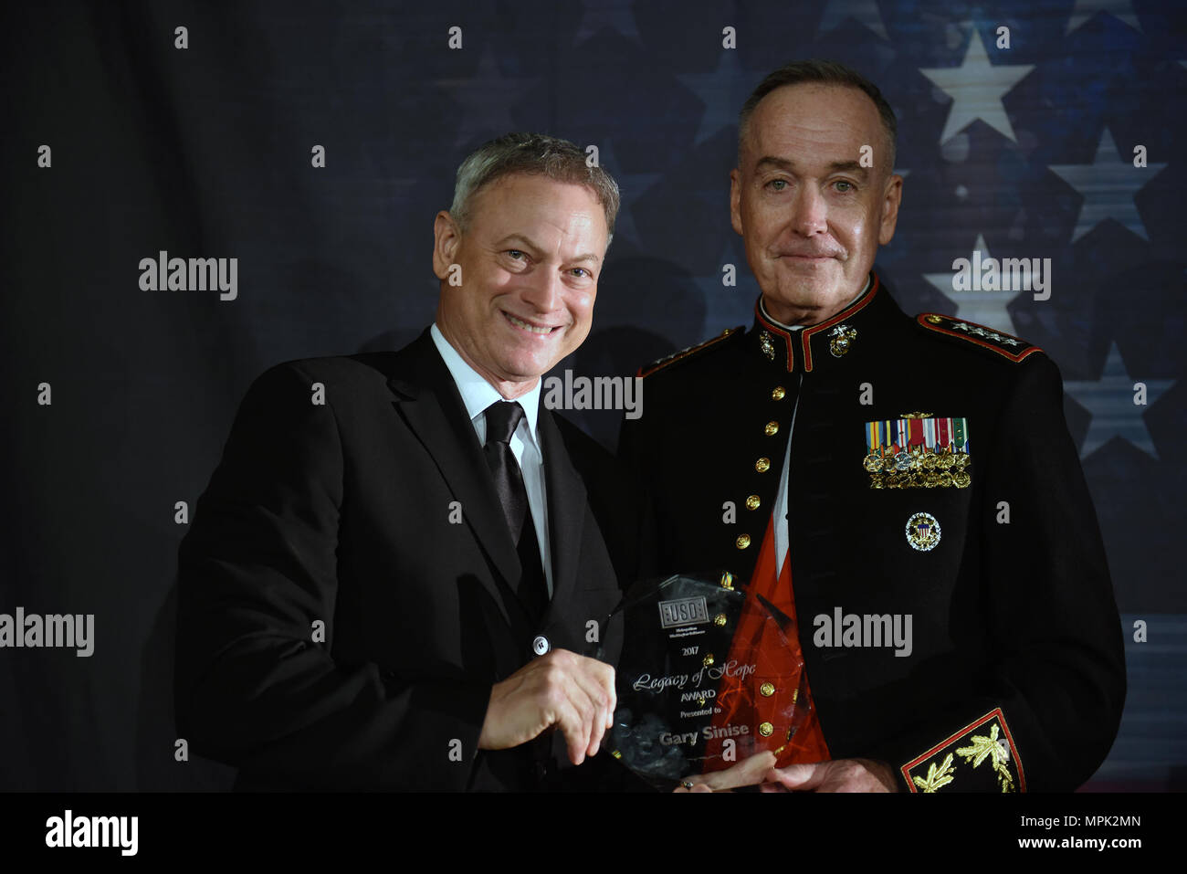 Marine Gen. Joseph Dunford, right, chairman of the Joint Chiefs of Staff, presents Gary Sinise, actor and humanitarian, the Legacy of Hope Award at the USO of Metropolitan Washington-Baltimore's 35th Annual Awards Dinner, Arlington, Va., March 21, 2017. (U.S. Army National Guard photo by Sgt. 1st Class Jim Greenhill) Stock Photo