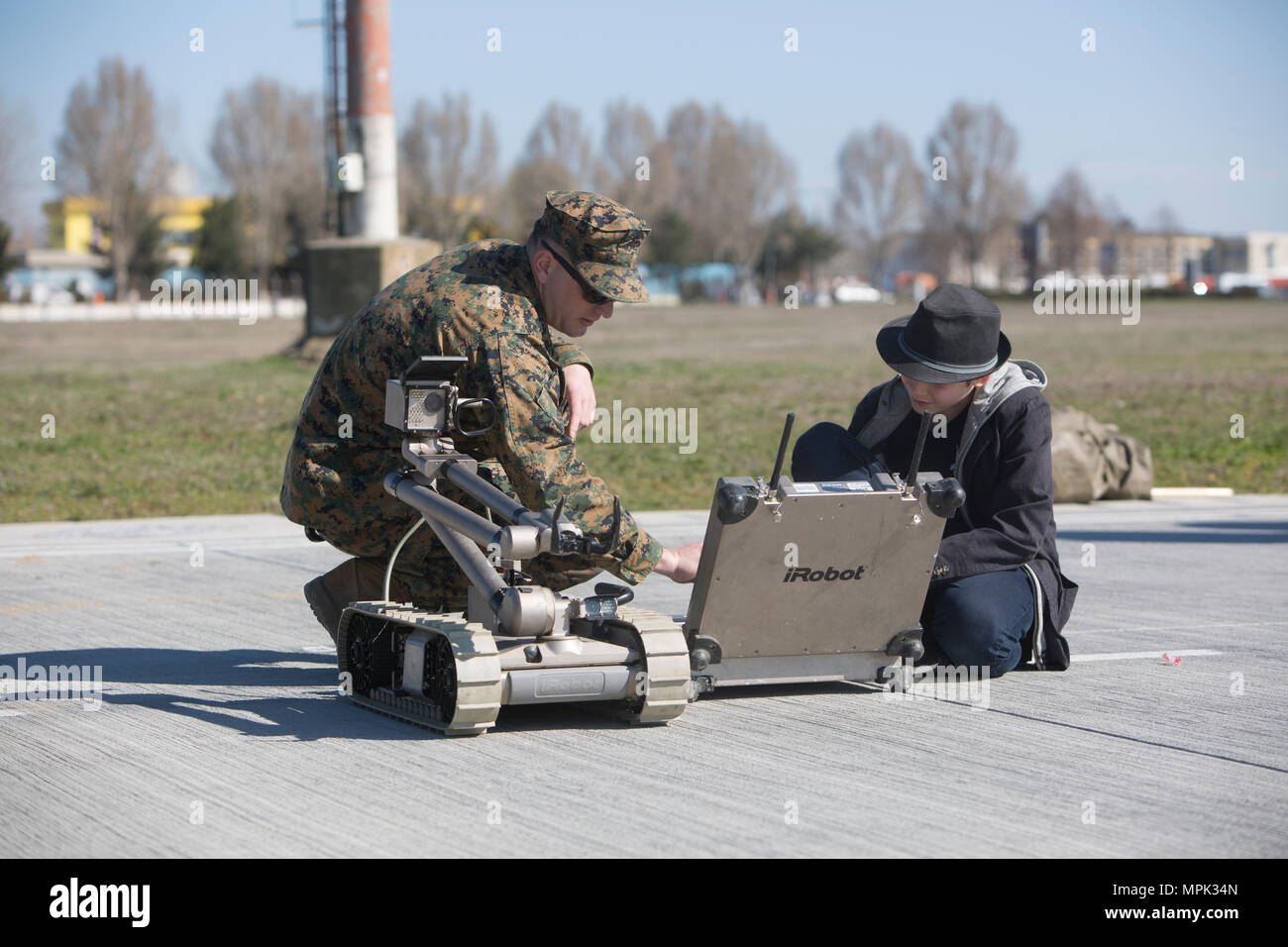 U.S. Marine explains the controls for the iRobot Packbot to a child ...