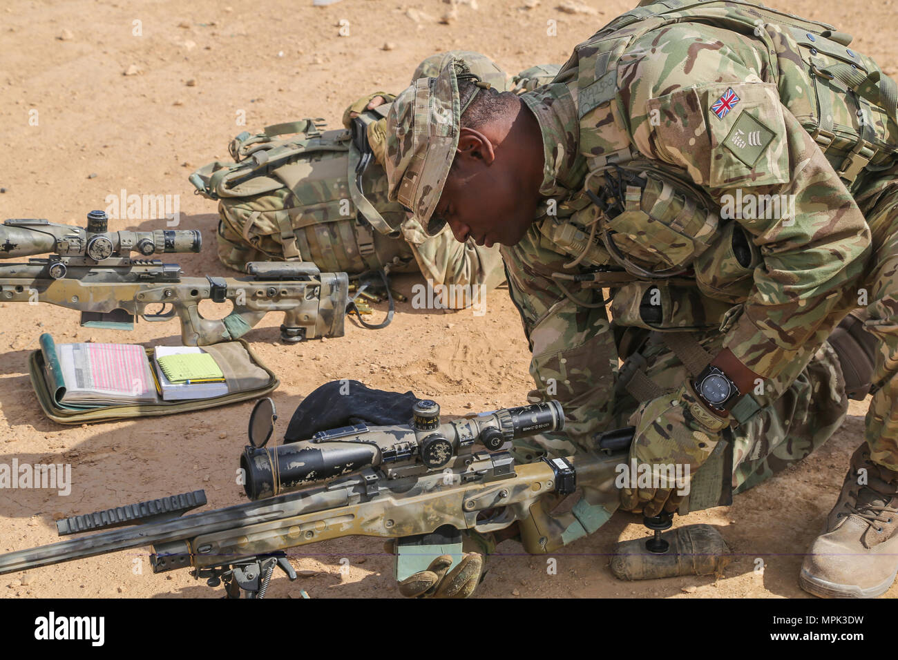 A British trainer deployed in support of Combined Joint Task Force – Operation Inherent Resolve and assigned to The Highlanders, 4th Battalion, The Royal Regiment of Scotland (4 Scots) loads a magazine into his L115A3 Long Range rifle during sniper training at Al Asad Air Base, Iraq, March 21, 2017. This training is part of the overall CJTF – OIR building partner capacity mission by training and improving the capability of partnered forces fighting ISIS. CJTF – OIR is the global Coalition to defeat ISIS in Iraq and Syria. (U.S. Army photo by Sgt. Lisa Soy) Stock Photo
