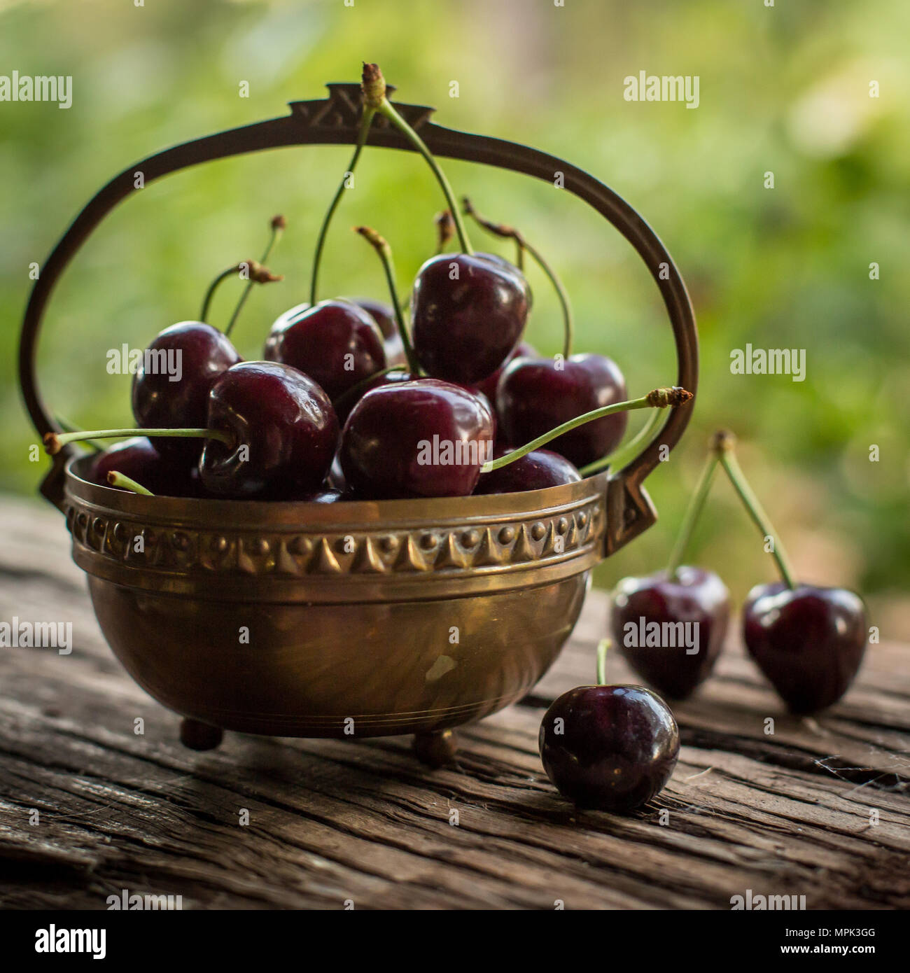 fresh red cherries in season in copper bowl Stock Photo Alamy