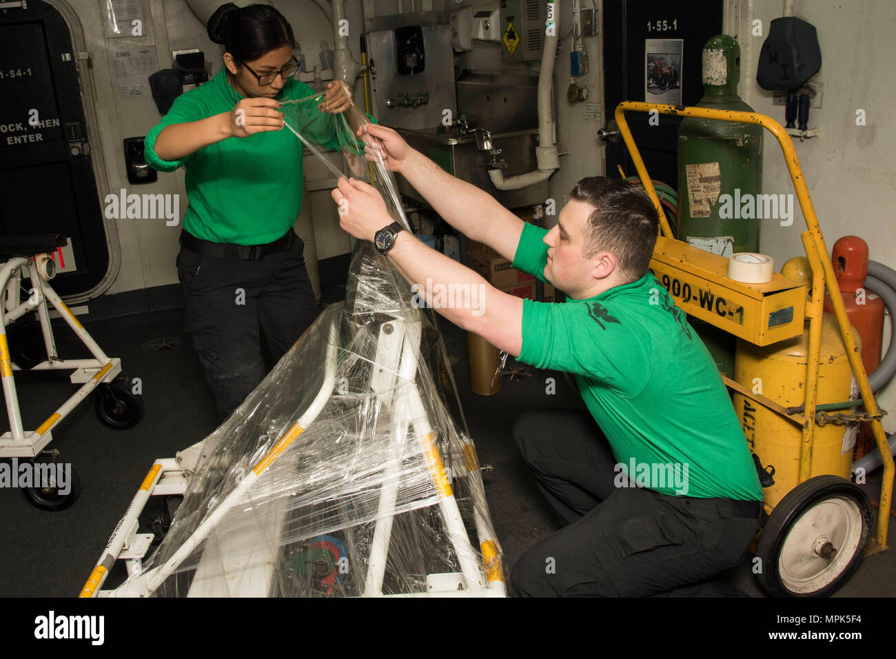 170322-N-KJ380-028  ATLANTIC OCEAN (March 22, 2017) Aviation Support Equiment Technician Airman Maya Condori, left, from Youngstown, Ohio, and Aviation Support Equipment Technician 3rd Class Adam Curry, from Halfmoon, N.Y., wrap equipment for preservation in the Aviation Intermediate Maintenance Department tunnel aboard the aircraft carrier USS Dwight D. Eisenhower (CVN 69) (Ike). Ike is currently conducting aircraft carrier qualifications during the sustainment phase of the Optimized Fleet Response Plan (OFRP). (U.S. Navy photo by Mass Communication Specialist Seaman Neo Greene III) Stock Photo