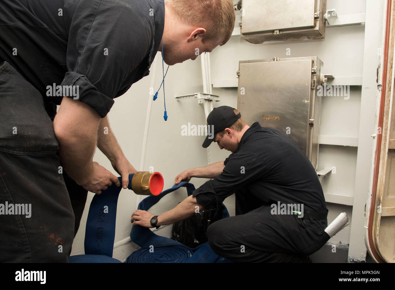 170322-N-KJ380-033  ATLANTIC OCEAN (March 22, 2017) Machinist's Mate 2nd Class Brian Darmstadt, from Elyria, Ohio, and Machinist's Mate 3rd Class Devon Lane, from Lexington, S.C., soak hoses for a hot water rig in a passageway aboard the aircraft carrier USS Dwight D. Eisenhower (CVN 69) (Ike). Ike is currently conducting aircraft carrier qualifications during the sustainment phase of the Optimized Fleet Response Plan (OFRP). (U.S. Navy photo by Mass Communication Specialist Seaman Neo Greene III) Stock Photo