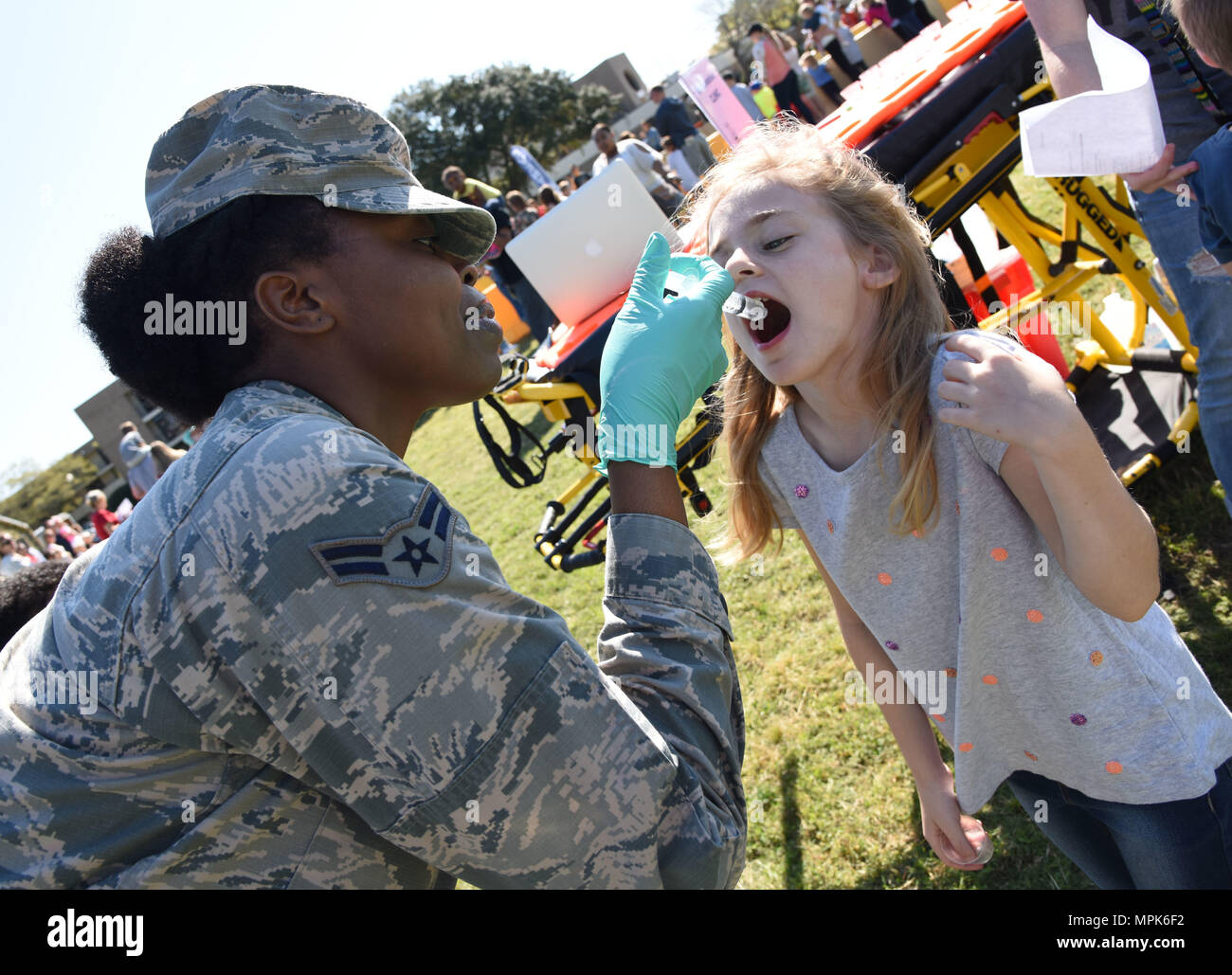 Airman 1st Class Chante Birdlong, 81st Medical Operations Squadron administration technician, administers juice to Madison Maxey, daughter of Kristen Maxey, during Operation Hero March 18, 2017, on Keesler Air Force Base, Miss. The activities at the event were designed to help children better understand what their parents do when they deploy. (U.S. Air Force photo by Kemberly Groue) Stock Photo