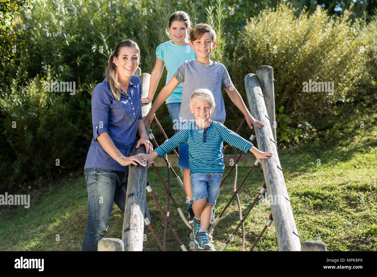 Family with kids playing on adventure playground Stock Photo