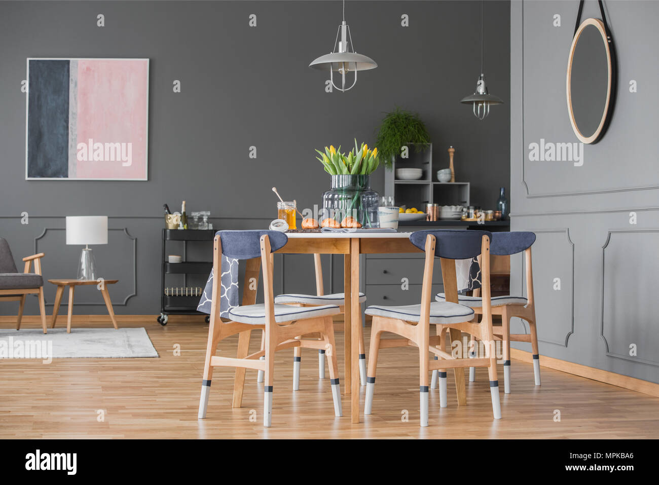 Round Mirror On Grey Wall With Molding In Open Space Interior With Dining Table And Pastel Painting Stock Photo Alamy
