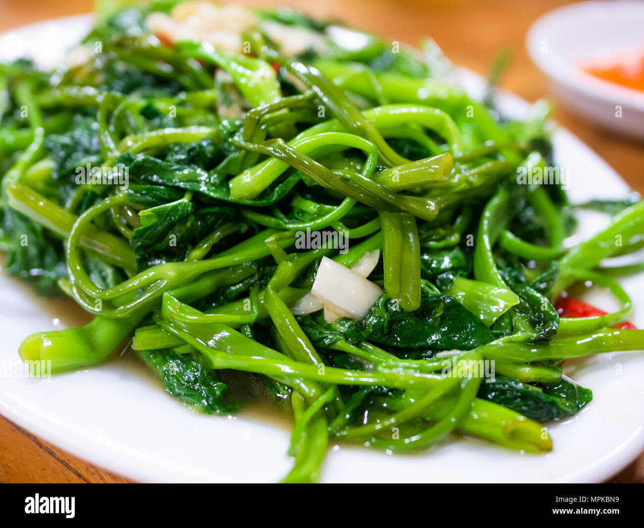 Vietnamese fried morning glory, rau muong xao toi. This is a popular dish across large parts of Asia, made with watercress or water spinach, chili pep Stock Photo