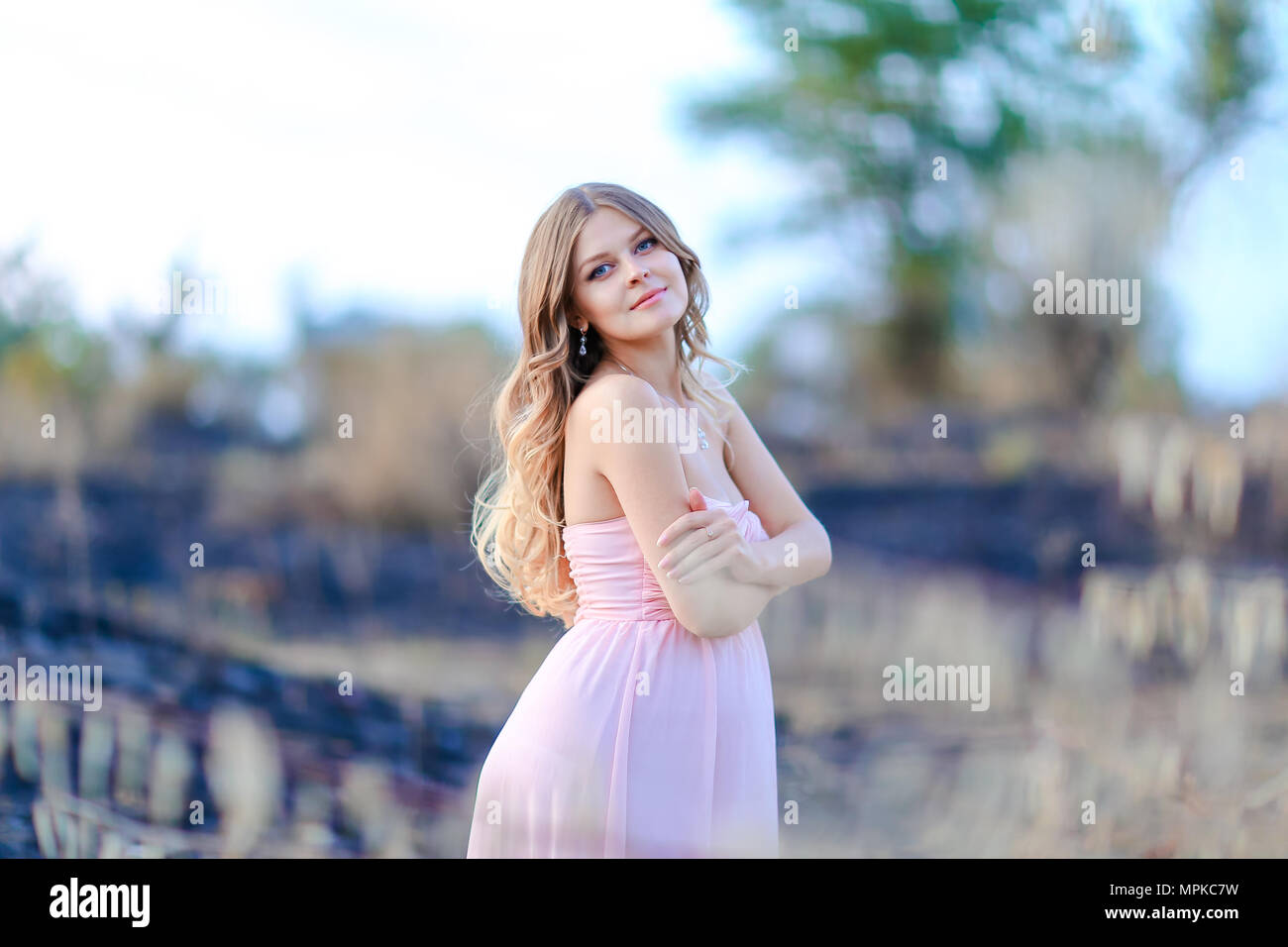 Happy pregnant woman wearing pink dress standing in blurred background  Stock Photo - Alamy