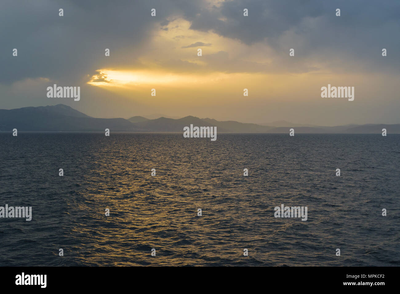 Sunset sunlight breaking through cloud seascape Stock Photo