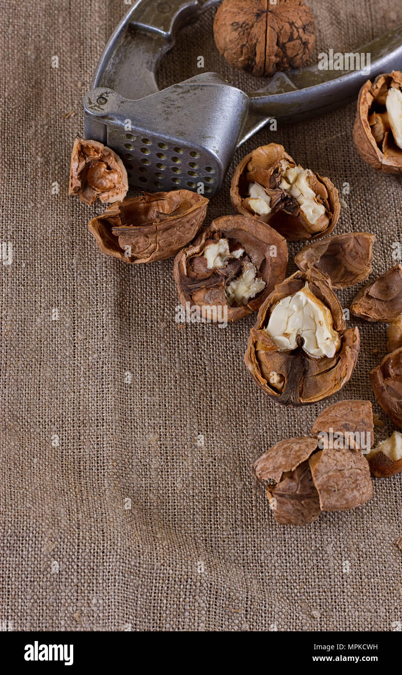 walnuts and a nutcracker on a table covered with burlap Stock Photo
