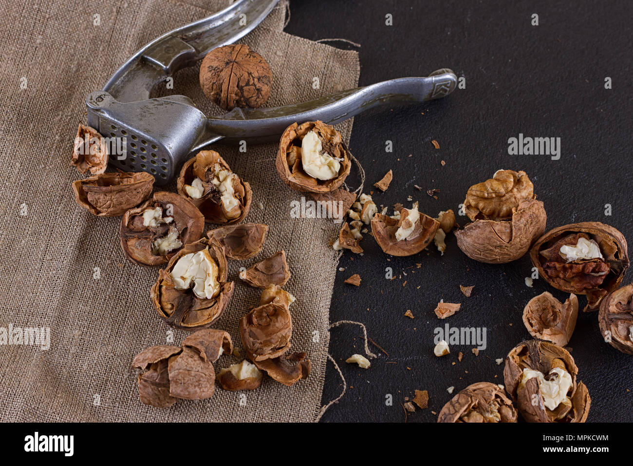 walnuts and a nutcracker on a table covered with burlap Stock Photo
