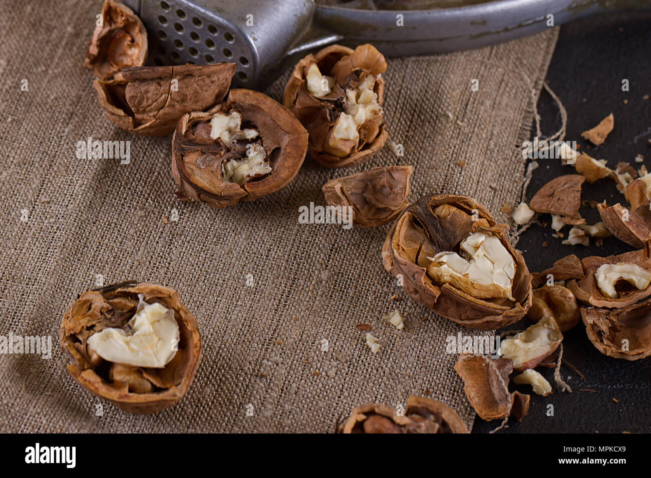 walnuts and a nutcracker on a table covered with burlap Stock Photo