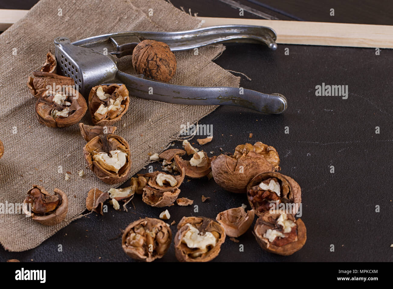 walnuts and a nutcracker on a table covered with burlap Stock Photo