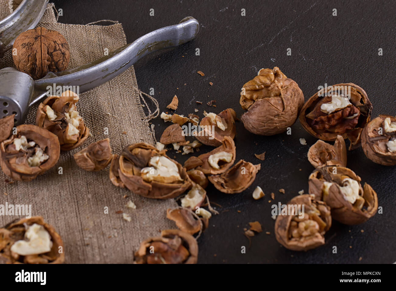 walnuts and a nutcracker on a table covered with burlap Stock Photo