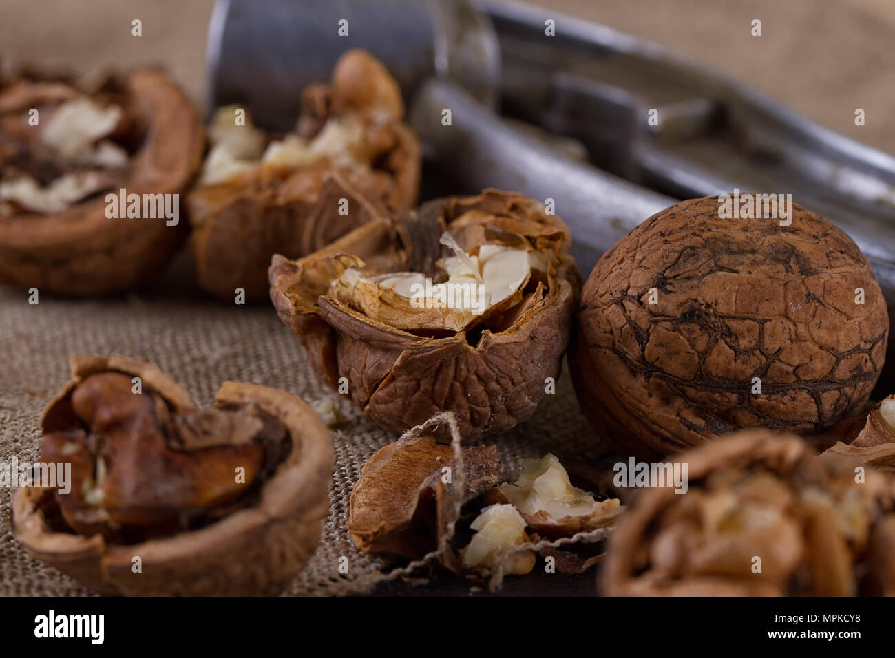 walnuts and a nutcracker on a table covered with burlap Stock Photo