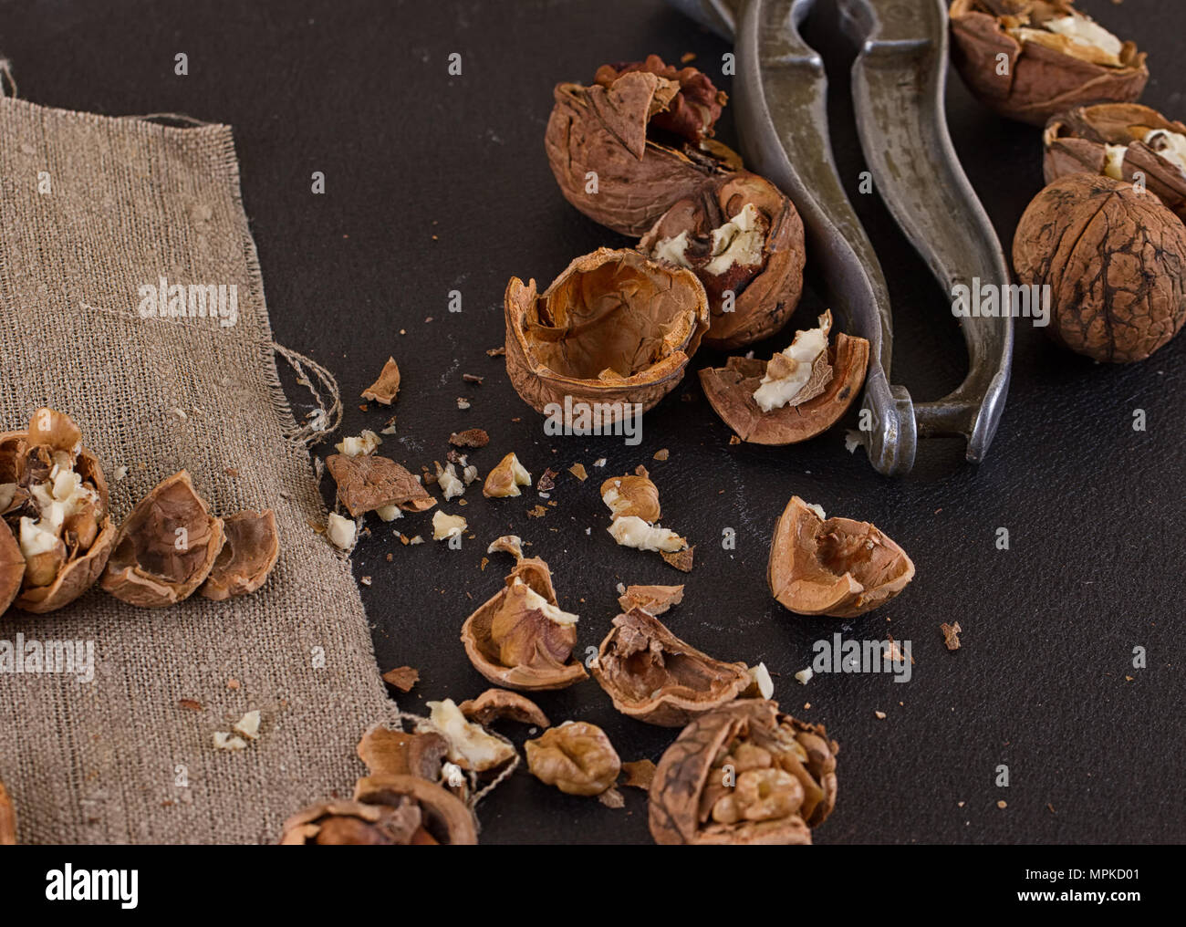 walnuts and a nutcracker on a table covered with burlap Stock Photo