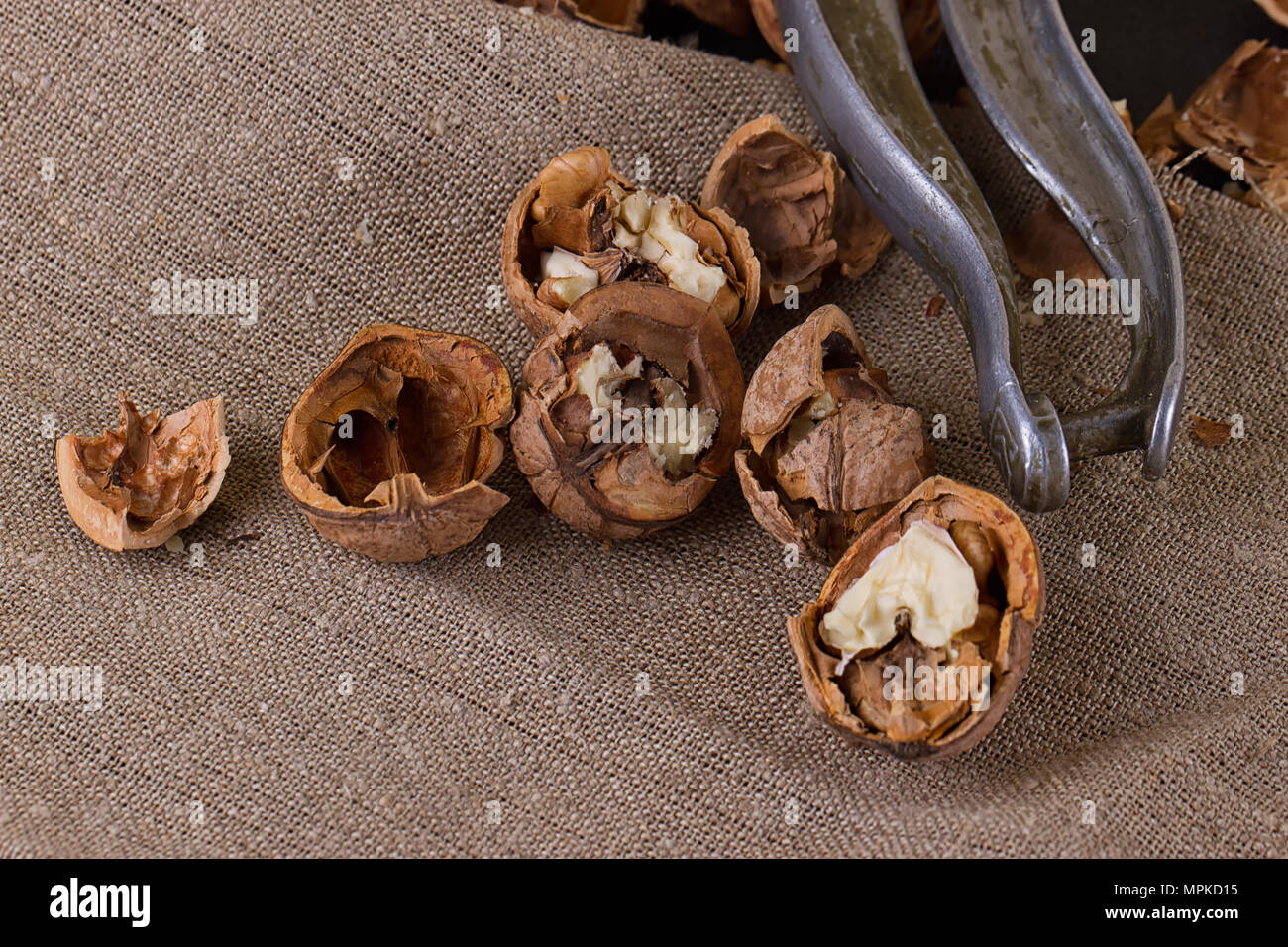 walnuts and a nutcracker on a table covered with burlap Stock Photo