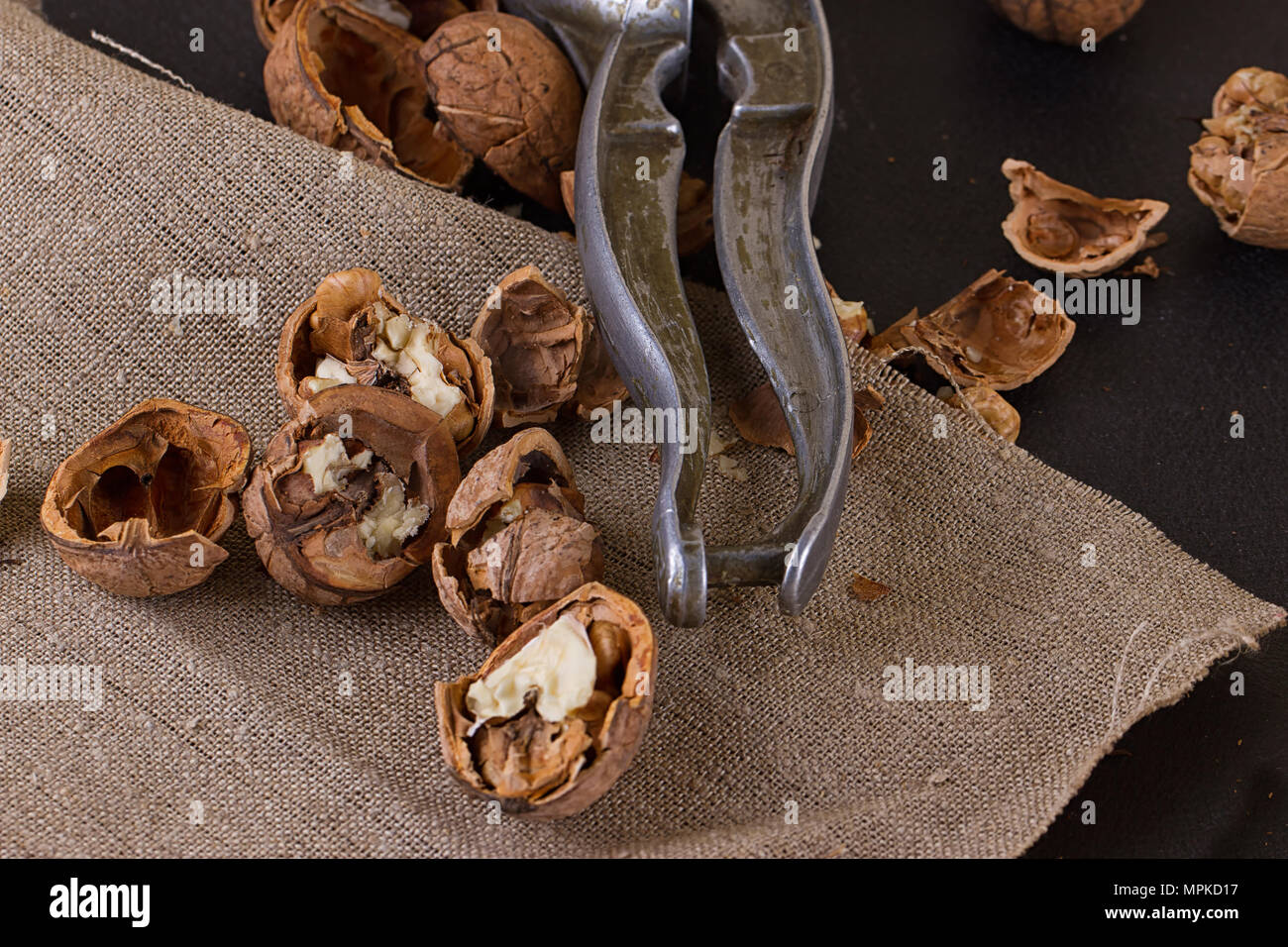 walnuts and a nutcracker on a table covered with burlap Stock Photo
