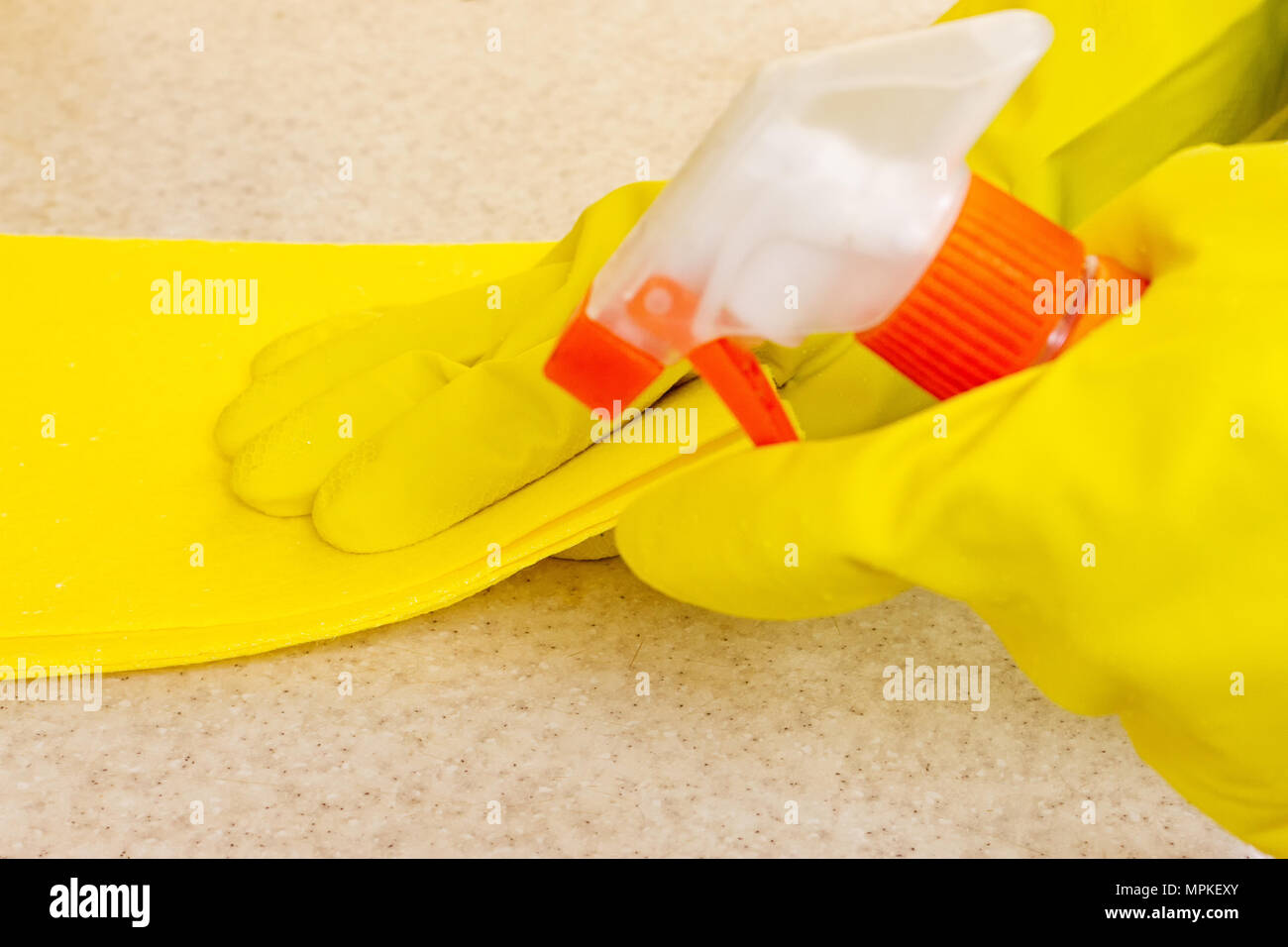 Hand in rubber glove cleans a new kitchen. Woman with housework