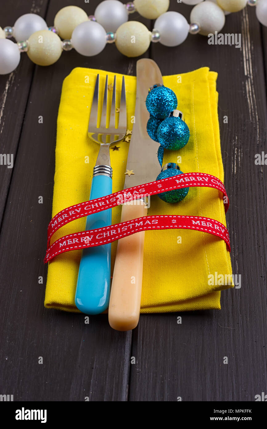 Christmas New Year background. set fork, knife, spoon on yellow napkin with decoration Holiday gold ribbon, Christmas blue ball Stock Photo