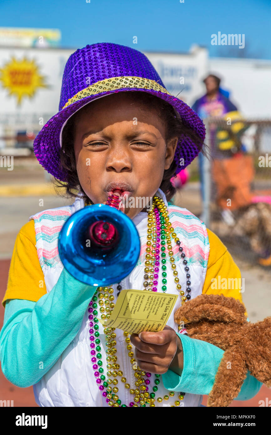 Small black male child dressed for Mardi gras with a purple hat and