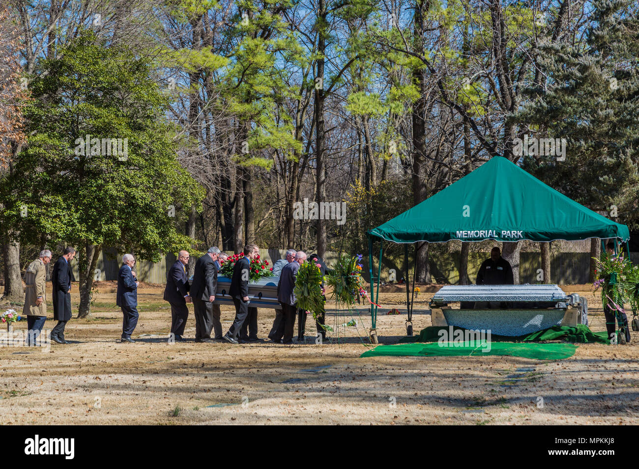 Poll bearers carry a flower draped casket to the burial site in a Memphis, Tennessee memorial park Stock Photo