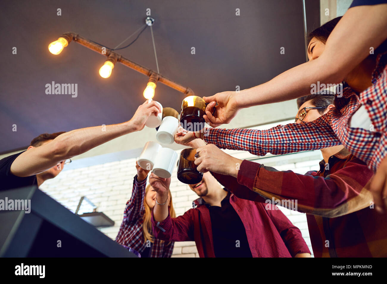 Friends raised their hands upwards with cup. Stock Photo