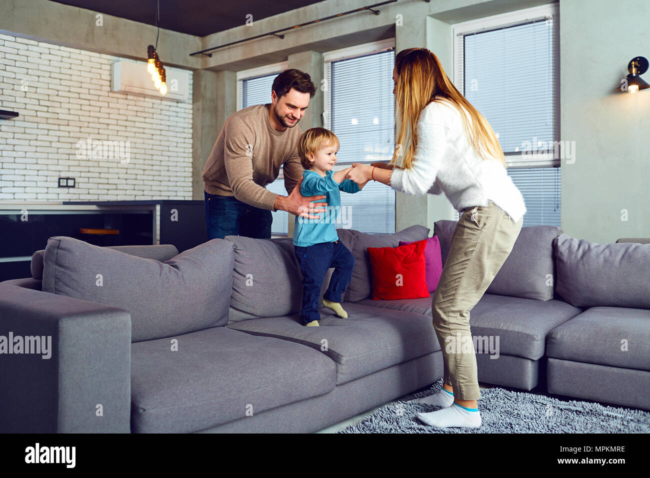A family is playing with a child in the room. Stock Photo