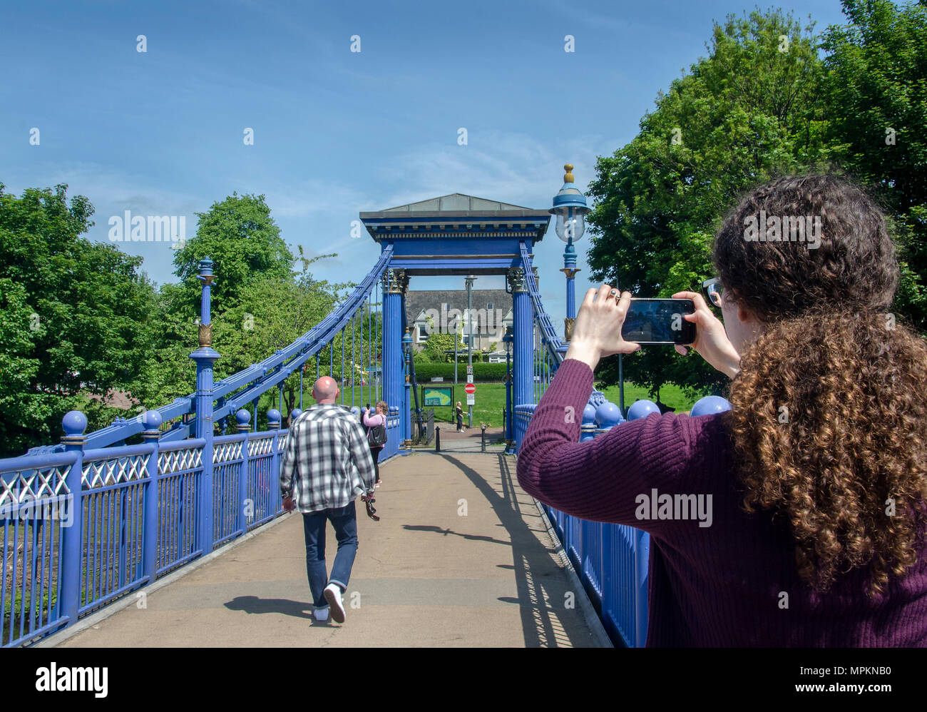 GLASGOW, SCOTLAND - MAY 23rd 2018: A woman takes a photograph of the St Andrews Suspension Bridge on her mobile. Stock Photo