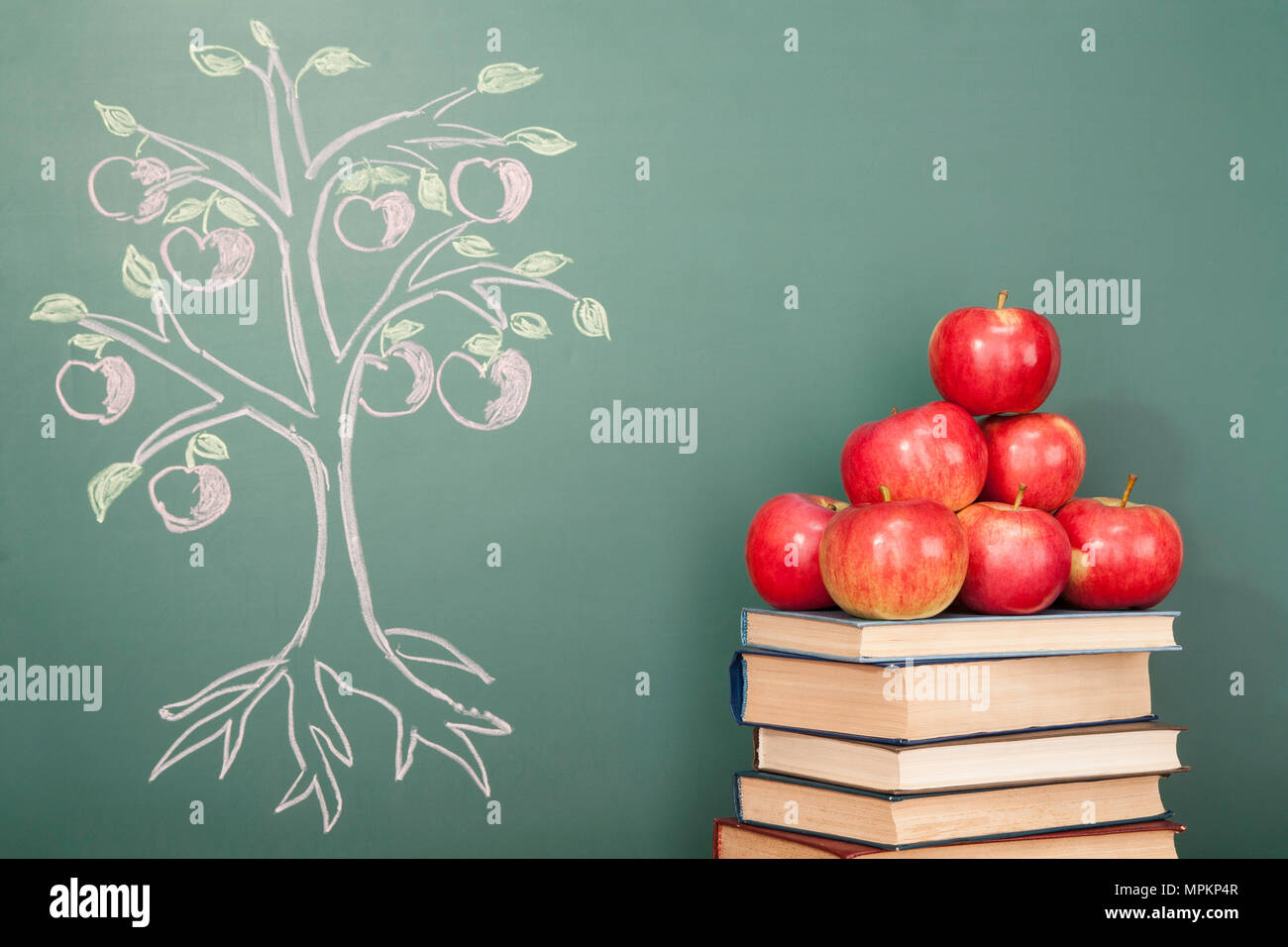 Education concept with apples and illustration of Apple tree on blackboard Stock Photo