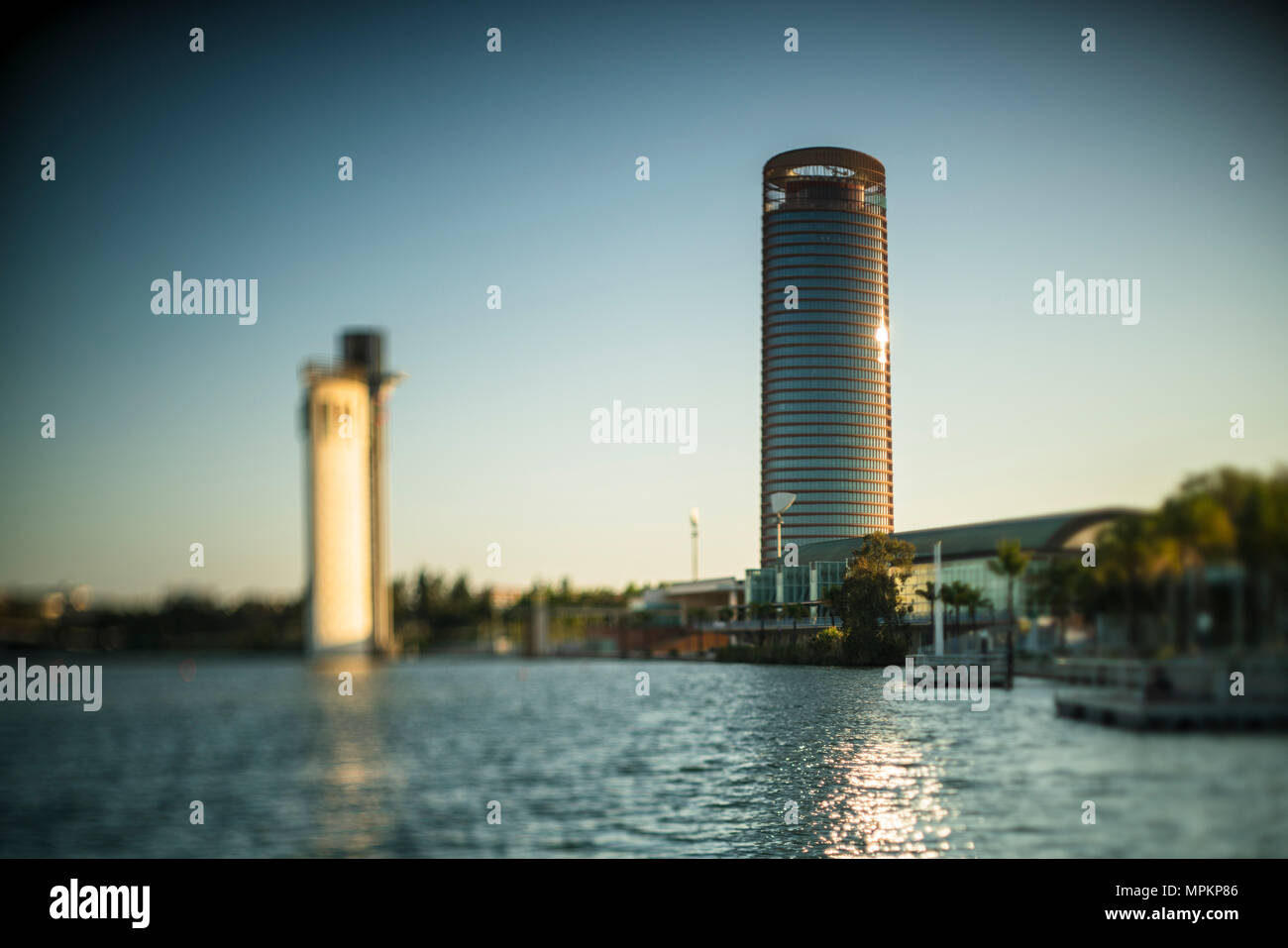 Torre Sevilla skyscraper (right) and Schindler tower (left, out of focus) by the Guadalquivir river, Seville, Spain. Shallow depth of field achieved b Stock Photo
