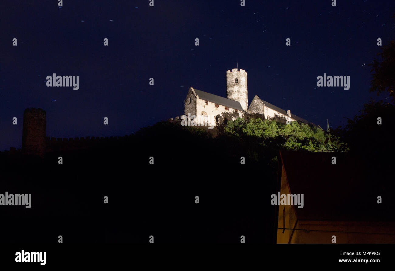 Panoramic view of Bezdez castle in the Czech Republic. In the foreground there are a house and trees, in the background is a hill with castle in the n Stock Photo