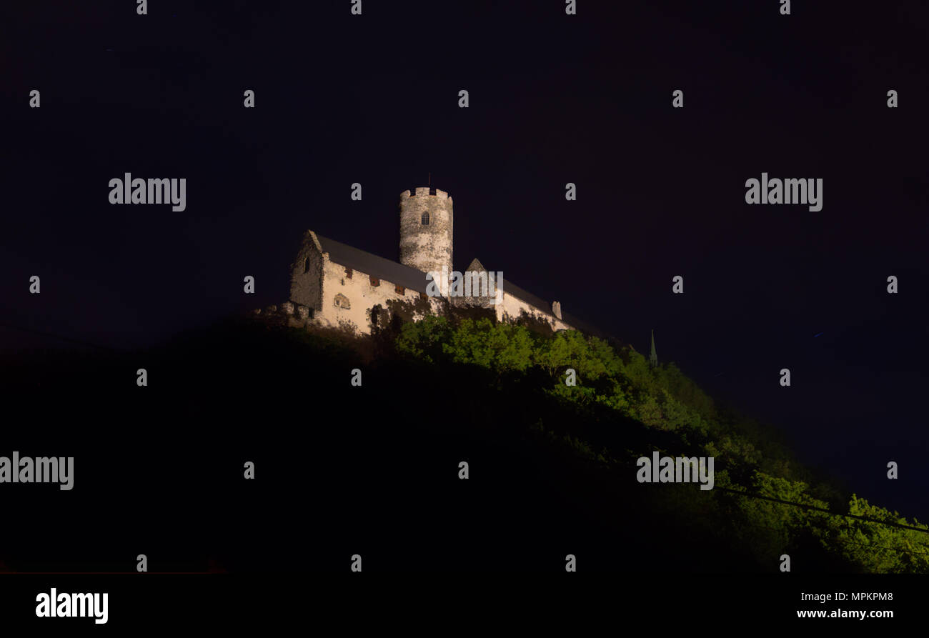 Panoramic view of Bezdez castle in the Czech Republic. In the foreground there are trees, in the background is a hill with castle in the night. Stock Photo