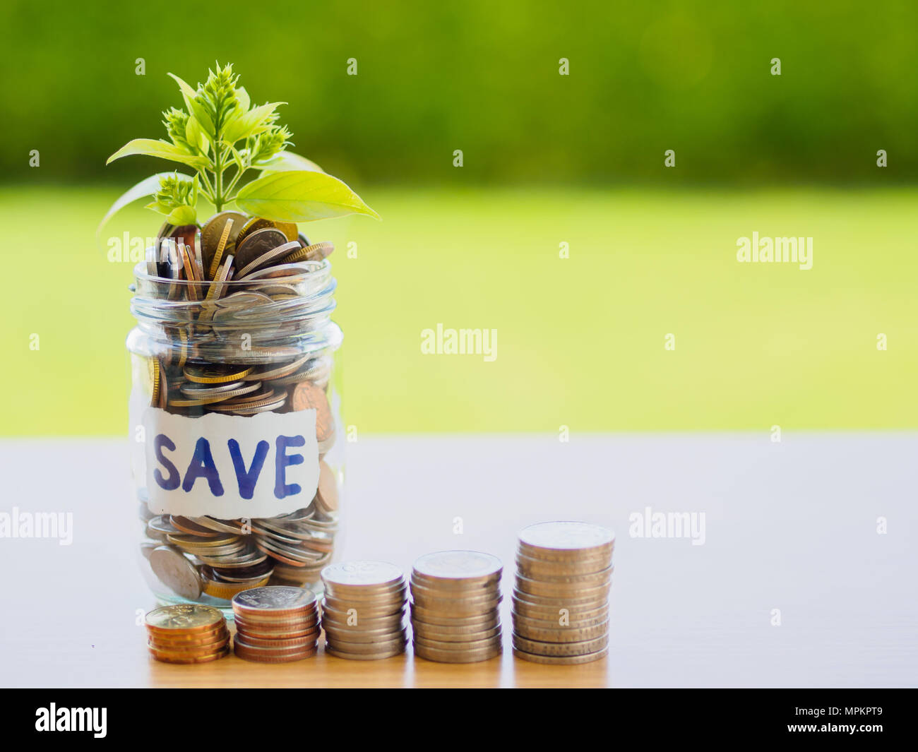 Abstract Money Saving Small Baby Tree With Glass Jar Coins With Stack Coins On Table With Green Tree Background Stock Photo Alamy