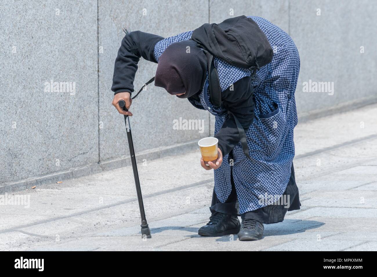 Old beggar woman bent over in a pedestrian zone, Germany Stock Photo