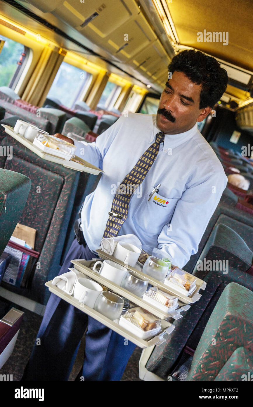 Montreal Canada,Quebec Province,VIA Rail,passenger train to Quebec City,Asian man,male porter,carries dinner trays,service,Canada070708113 Stock Photo