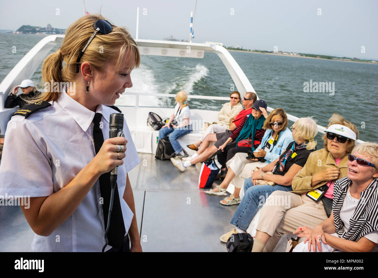Quebec Canada,St. Lawrence River,Coudrier Cruises tour boat to Grosse Ile,woman female women,guide,microphone,passenger passengers rider riders,Canada Stock Photo