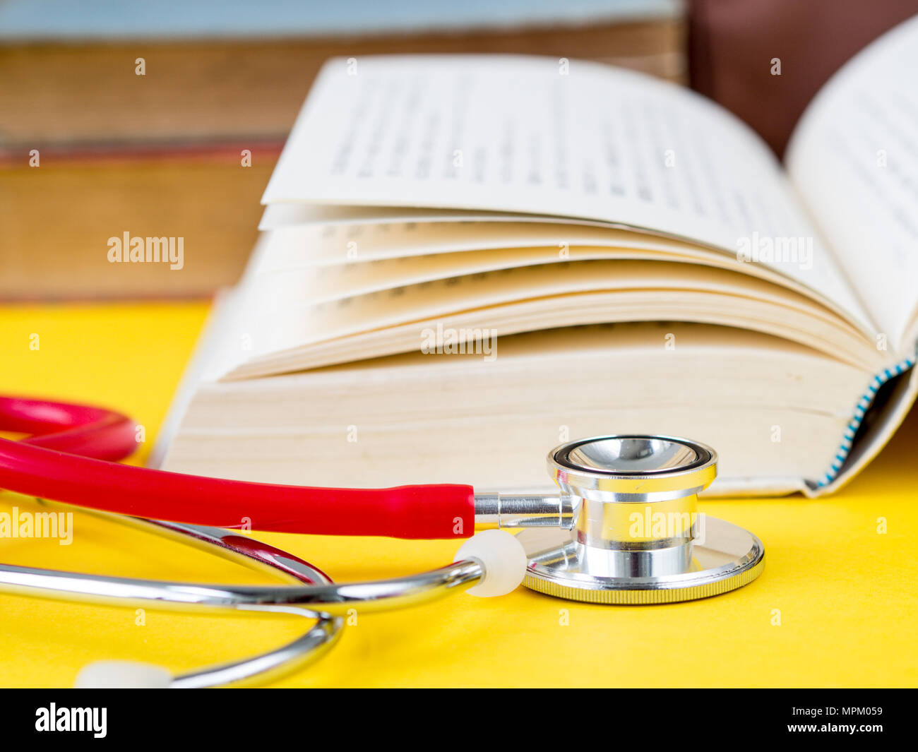 Stack of books and a stethoscope on yellow table background Stock Photo ...