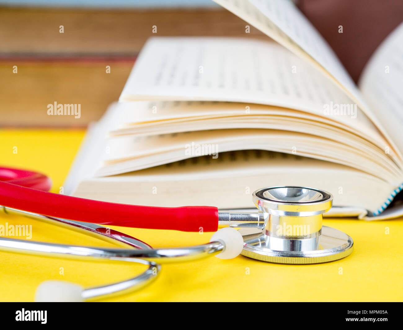Stack of books and a stethoscope on yellow table background Stock Photo ...