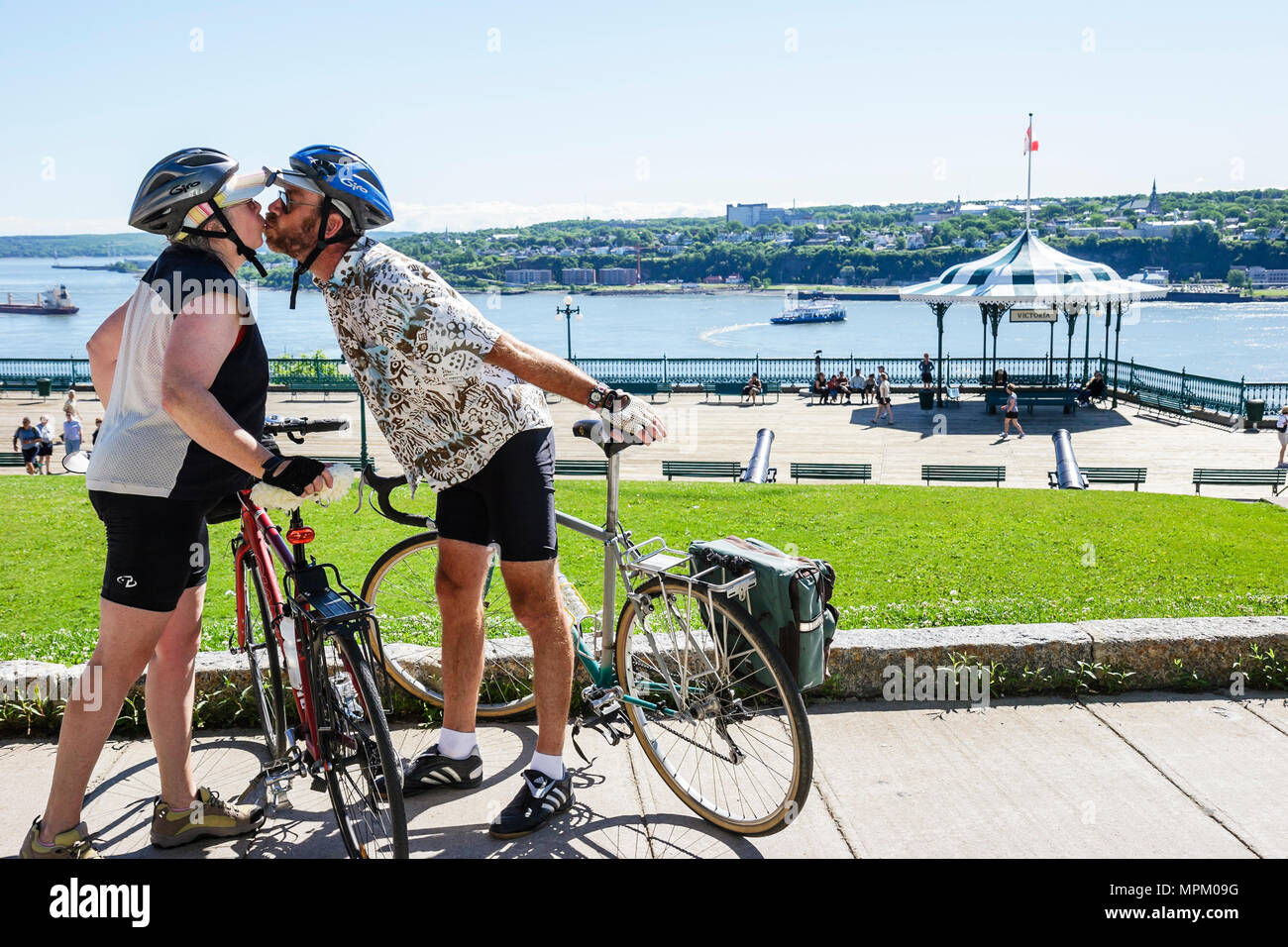 Quebec Canada,Upper Town,Terrasse Dufferin,St. Lawrence River,couple,man men male,woman female women,kissing,bicycle,bicycling,riding,biking,rider,bik Stock Photo
