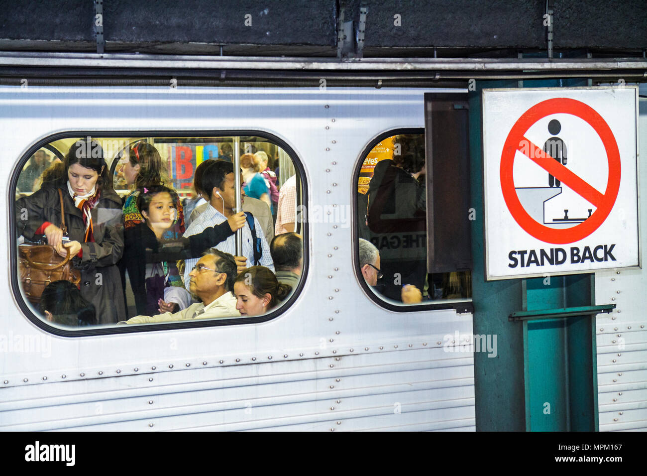 Toronto Canada,TTC subway,Bloor Yonge Station,Yonge Yellow Line,passenger passengers rider riders,commuter,commuters,crowded train,window,Asian woman Stock Photo