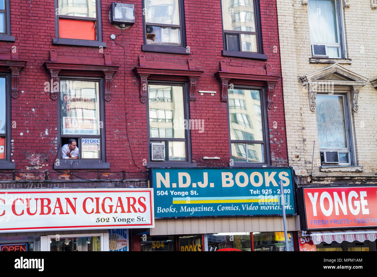Toronto Canada,Yonge Street,red brick,dilapidated building,man men male adult adults,looking out window,Tabac Cuban Cigars,tobacco,French word,store,s Stock Photo