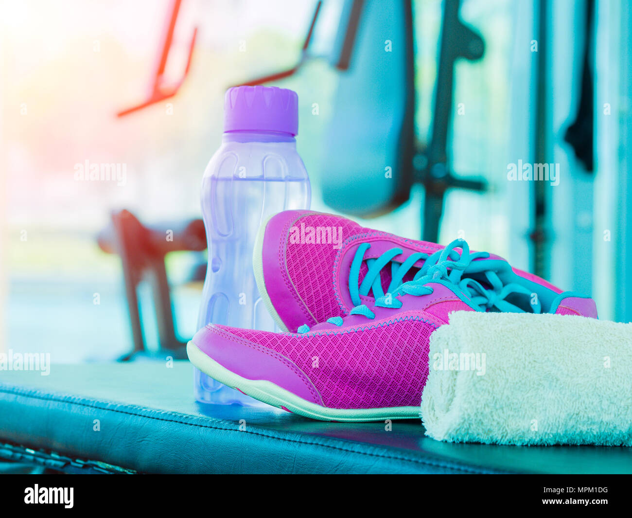 Pair of pink sport shoes towel water bottle in fitness room with fitness  equipments background. Accessories for running sport and exercise Stock  Photo - Alamy