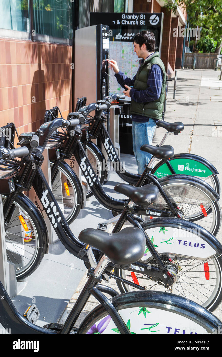 Toronto Canada,Granby Street,Bixi bike bicycle share sharing station,rental,pay machine,man men male adult adults,young,commuting,North America Canada Stock Photo